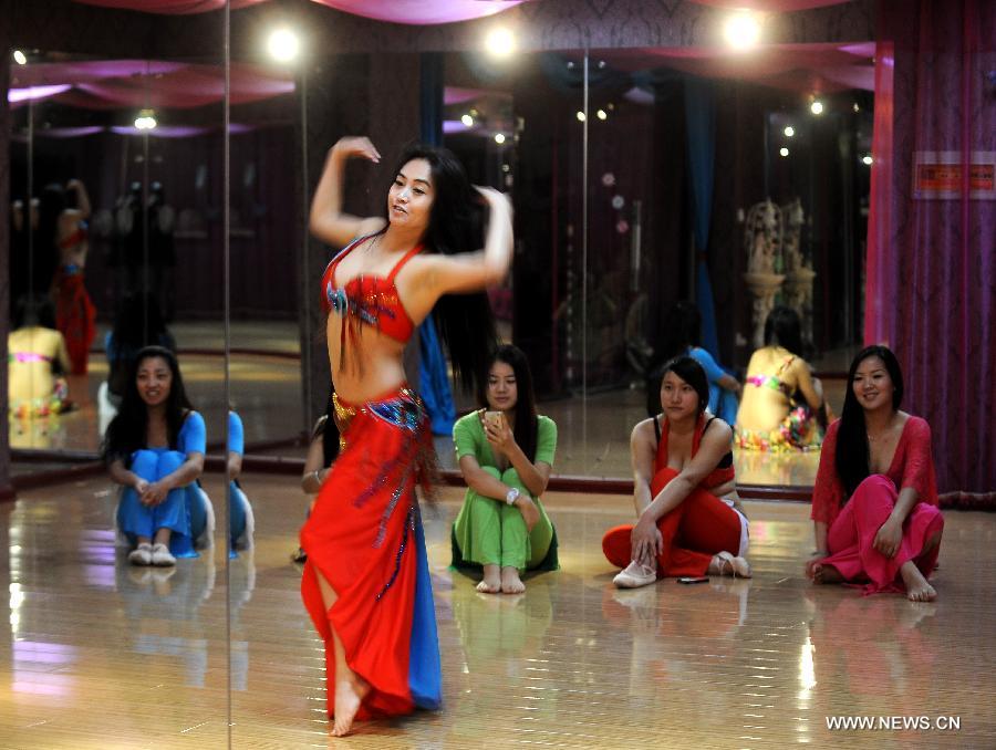 Belly dance trainer Guan Fang demonstrates for her students in Taiyuan, capital of north China's Shanxi Province, Dec. 3, 2012. Belly dance became more and more popular among China's young people as a means of physical exercises. (Xinhua/Yan Yan)