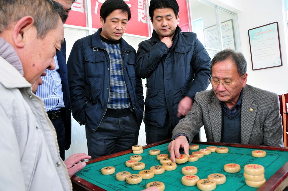 Kim Byungcho (L) writes with a brush pen at home in Rushan, east China's Shandong Province, Jan. 19, 2012.(Xinhua Photo) 