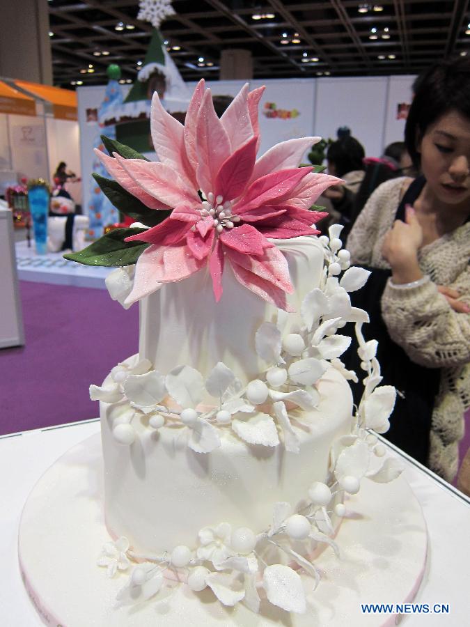 A visitor looks at a cream cake model exhibited at the Hong Kong International Bakery Expo in Hong Kong, south China, Dec. 5, 2012. The three-day bakery event kicked off here Wednesday, involving participants from home and abroad. (Xinhua/Zhao Yusi)