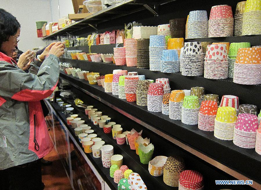 A visitor takes photos of paper cups used for bakery products at the Hong Kong International Bakery Expo in Hong Kong, south China, Dec. 5, 2012. The three-day bakery event kicked off here Wednesday, involving participants from home and abroad. (Xinhua/Zhao Yusi)