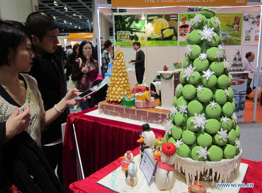 A visitor takes photos of a cake model exhibited at the Hong Kong International Bakery Expo in Hong Kong, south China, Dec. 5, 2012. The three-day bakery event kicked off here Wednesday, involving participants from home and abroad. (Xinhua/Zhao Yusi)