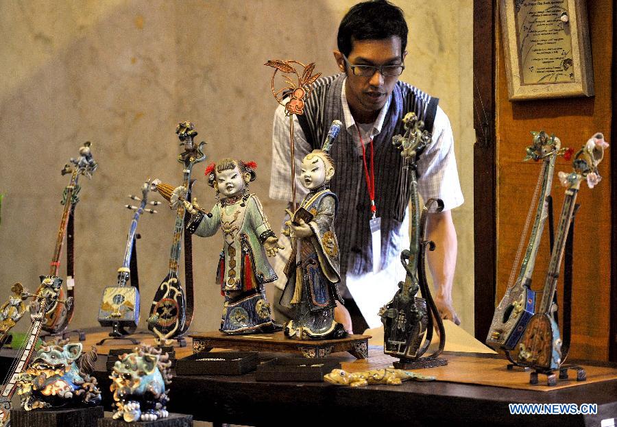 A man watches handmade ceramics at Katumbiri Expo 2012, a part of Indonesian economic creative product expo, in Jakarta, Indonesia, Dec. 5, 2012. (Xinhua/Agung Kuncahya B.) 