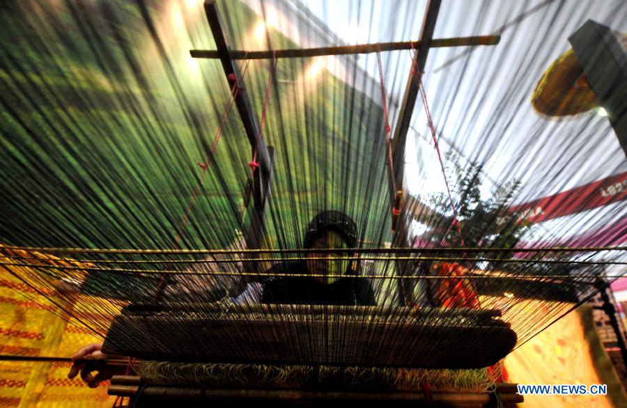 A woman weaves a traditional cloth at Katumbiri Expo 2012, a part of Indonesian economic creative product expo, in Jakarta, Indonesia, Dec. 5, 2012. (Xinhua/Agung Kuncahya B.)