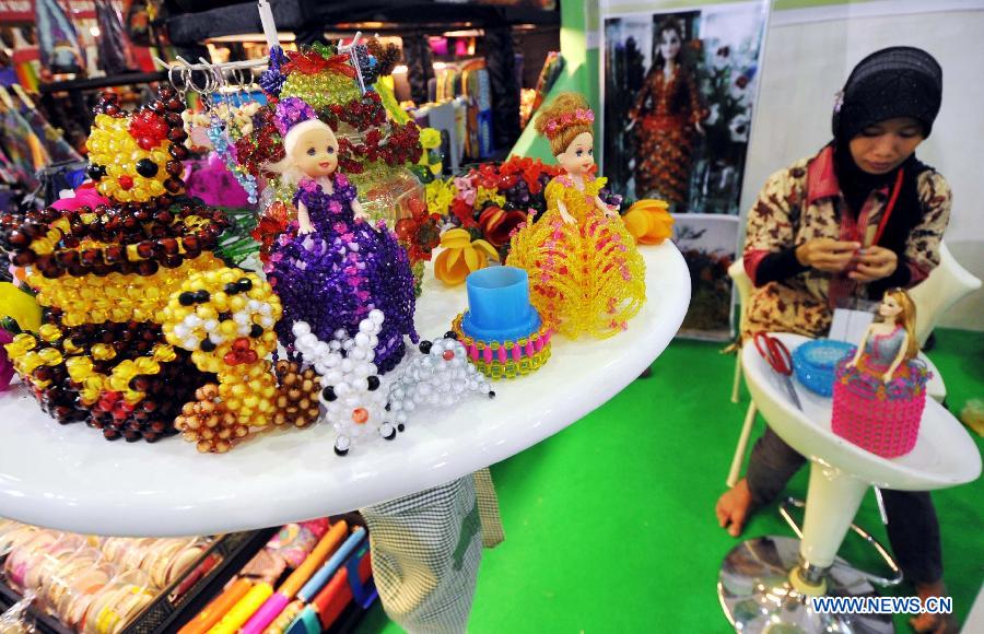 An Indonesian woman makes beads ornaments at Katumbiri Expo 2012, a part of Indonesian economic creative product expo, in Jakarta, Indonesia, Dec. 5, 2012. (Xinhua/Agung Kuncahya B.)