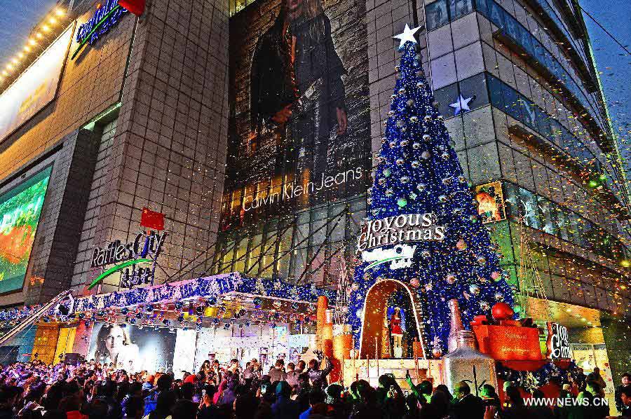 People gather to see a Christmas tree illuminate during a lighting ceremony celebrating the upcoming Christmas and new year in Shanghai, east China, Dec. 5, 2012. (Xinhua/Guo Changyao)