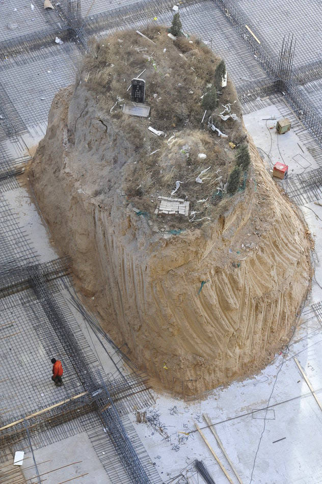 A lone tomb stands on a hillock at the construction site of a residential apartment project in Taiyuan on Dec, 5. 2012. (Yu Wei/ Icpress)