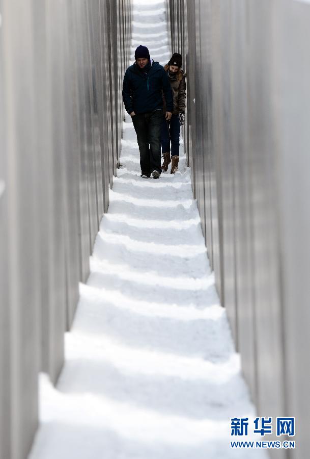 Two young people walk through the Jewish Memorial area in Berlin, Germany, Dec. 06, 2012. Berlin had its first heavy snow since winter on that day. (Xinhua/Ma Ning)