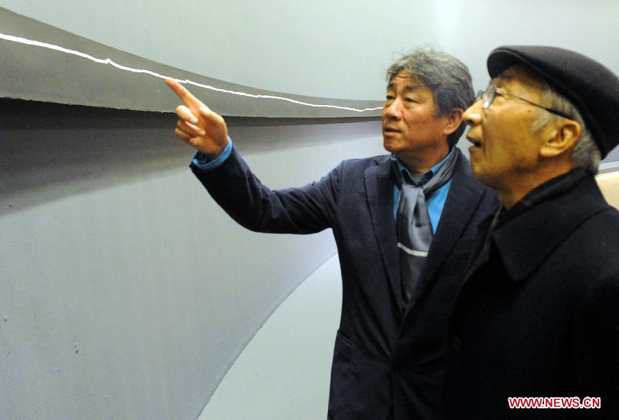 Abstract artist Tan Ping (L) introduces his work "+40m" at his solo exhibition "A Line" at the National Art Museum of China (NAMOC) in Beijing, capital of China, Dec. 7, 2012. The one-week exhibition which opened Friday at NAMOC displays more than 100 works of Tan Ping, who is also vice chancellor of China Central Academy of Fine Arts. (Xinhua/Tang Zhaoming) 