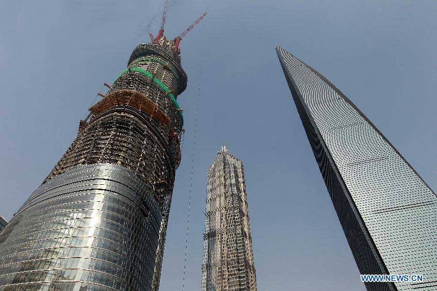 Photo taken on Dec. 8, 2012 shows the Shanghai Tower (L), a skyscraper under construction, along with the neighbouring Jin Mao Tower (C) and the Shanghai World Financial Center in Pudong, east China's Shanghai Municipality. The Shanghai Tower is expected to reach 632 meters in height and start service in 2015. (Xinhua/Pei Xin) 