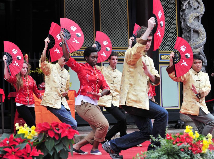 Exchange students perform Tai Chi fan at Taipei Confucius Temple during their coming-of-age ceremony in Taipei, southeast China's Taiwan, Dec. 9,2012. In total 130 exchange students from 18 countries and regions attend their coming-of-age ceremony on Sunday, including capping ceremony for boys and hair-pinning ceremony for girls. (Xinhua/Wu Ching-teng)