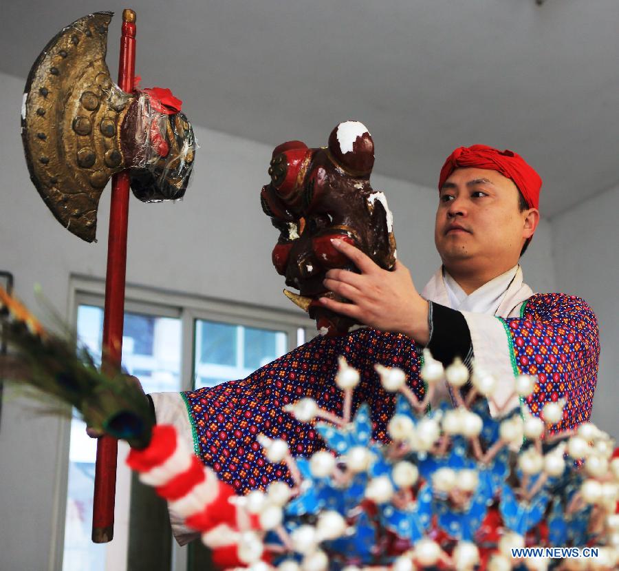 A Nuo dance artist makes preparations for performance in Jiangwan Town of Wuyuan County, east China's Jiangxi Province, Dec. 9, 2012. (Xinhua/Zhang Weiguo)