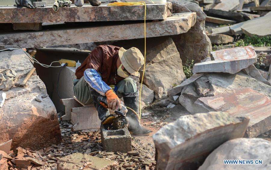 A craftsman cuts a rough stone in Changyang Tujia Autonomous County, central China's Hubei Province, Dec. 8, 2012. Located close to the Qingjiang River, the county is abundant in "Qingjiang Stone", of which natural colors and grains enable people here to develop it into ornamental stones. The stone industry has provided over 35,000 jobs for the people in the county, contributing greatly to the local economic development. (Xinhua/Cheng Min)