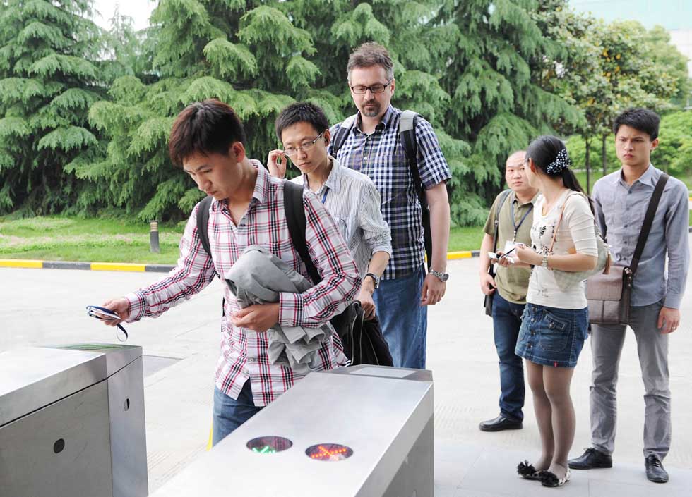 Anatoly Burov (3rd L) prepares to register after work in Shanghai, east China, May 7, 2012.(Xinhua/Lai Xinlin) 