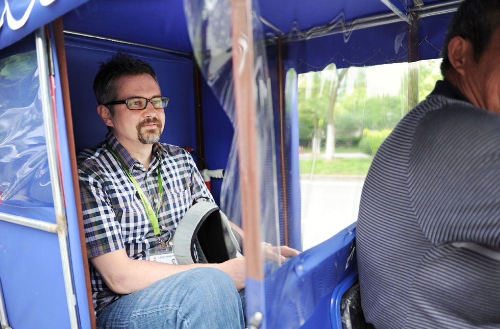 Anatoly Burov comes to the nearby subway station by motorcycle in Shanghai, east China, May 7, 2012. (Xinhua/Lai Xinlin) 