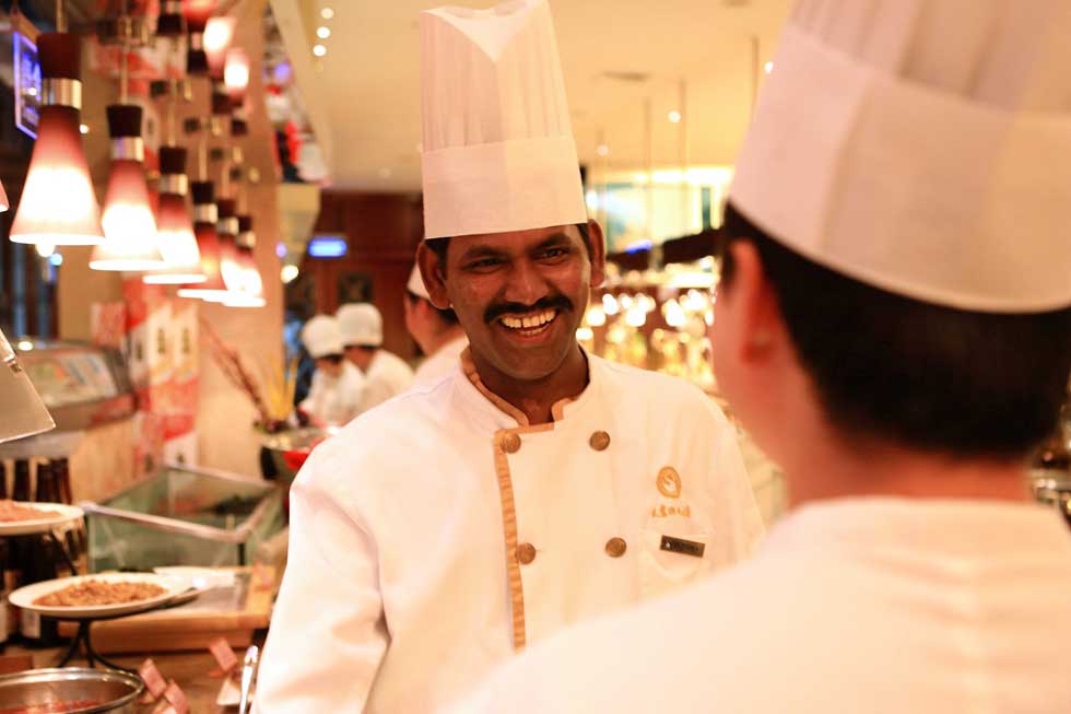 Pandi (L) talks to a Chinese cook in a buffet restaurant in Hefei, capital of east China's Anhui Province, June 15, 2012. 