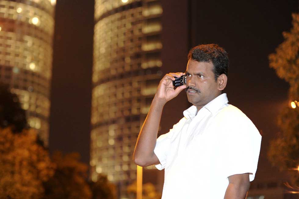 Pandi makes a phone call to his friend on the way home after work in Hefei, capital of east China's Anhui Province, July 11, 2012. 