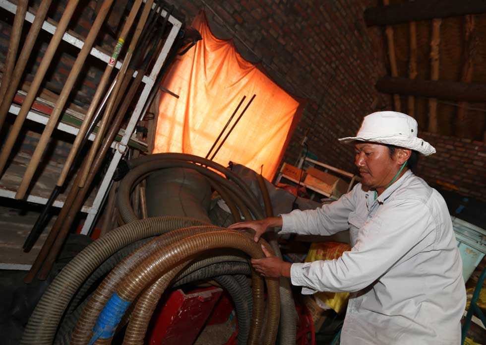 Mase Hiroki arranges pipes in his tool house in Engebei, Ordos, north China's Inner Mongolia Autonomous Region, Aug. 26, 2012.(Xinhua/Xie Xiudong)