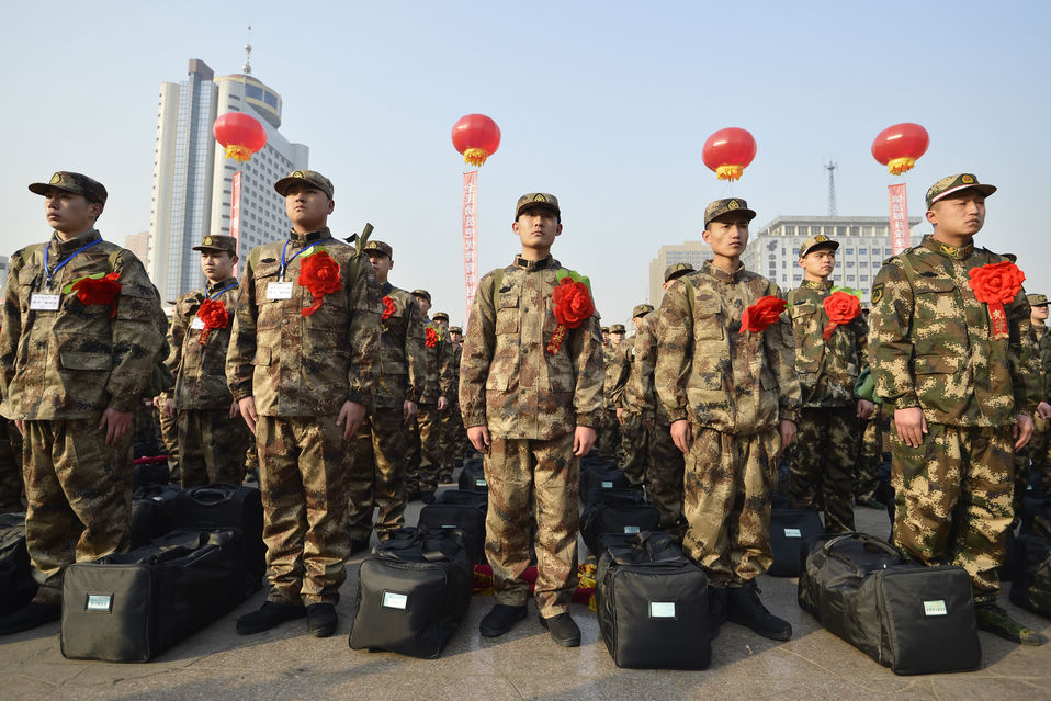 New recruits for the People's Liberation Army wait for the train to leave at a train station. The People's Liberation Army has launched its annual winter conscription this year. (Xinhua)