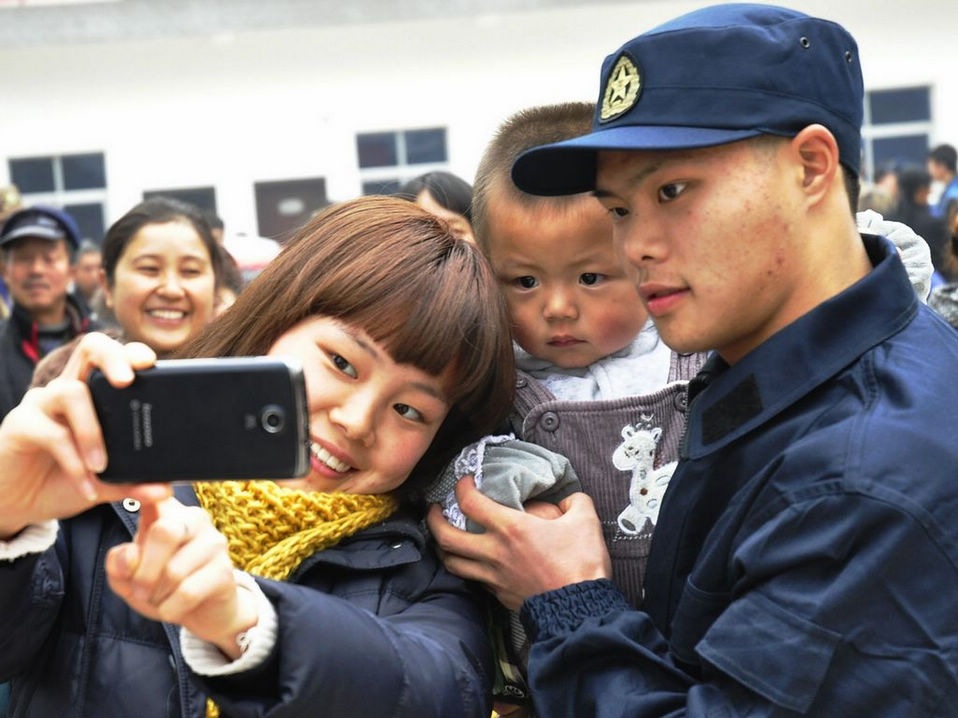 New recruits for the People's Liberation Army wait for the train to leave at a train station. The People's Liberation Army has launched its annual winter conscription this year. (Xinhua)