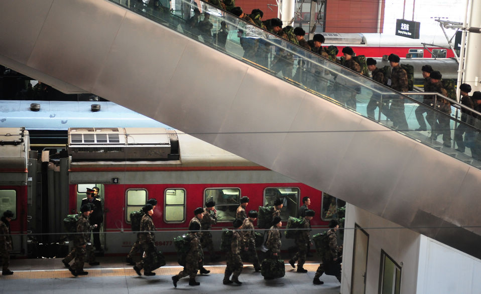 New recruits for the People's Liberation Army wait for the train to leave at a train station. The People's Liberation Army has launched its annual winter conscription this year. (Xinhua)