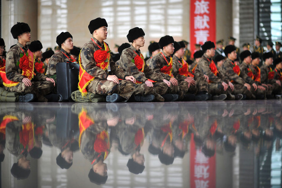 New recruits for the People's Liberation Army wait for the train to leave at a train station. The People's Liberation Army has launched its annual winter conscription this year. (Xinhua)