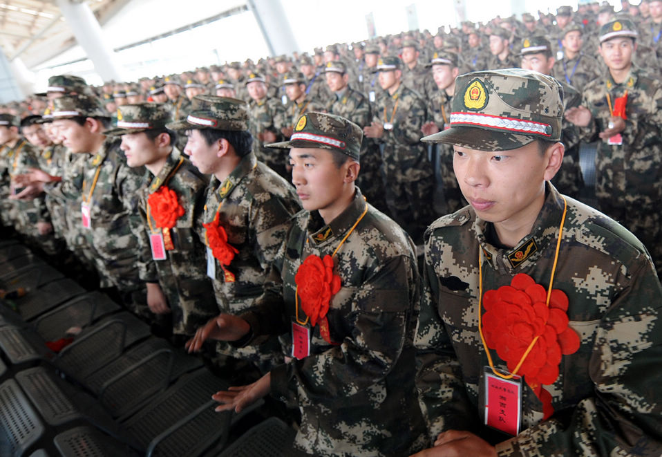 New recruits for the People's Liberation Army wait for the train to leave at a train station. The People's Liberation Army has launched its annual winter conscription this year. (Xinhua)