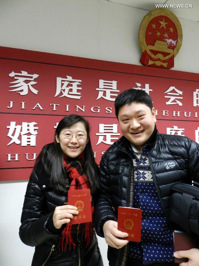 A young couple show their marriage certificates at a civil affairs bureau in Beijing, capital of China, Dec. 12, 2012. Young couples across the country rushed to get married on Dec, 12, 2012, or 12/12/12, hoping that the "triple 12 day" will bring them good luck. In Chinese, the number 12 is pronounced like "Yao Ai", meaning "To Love" in English. (Xinhua/Wang Zhen)