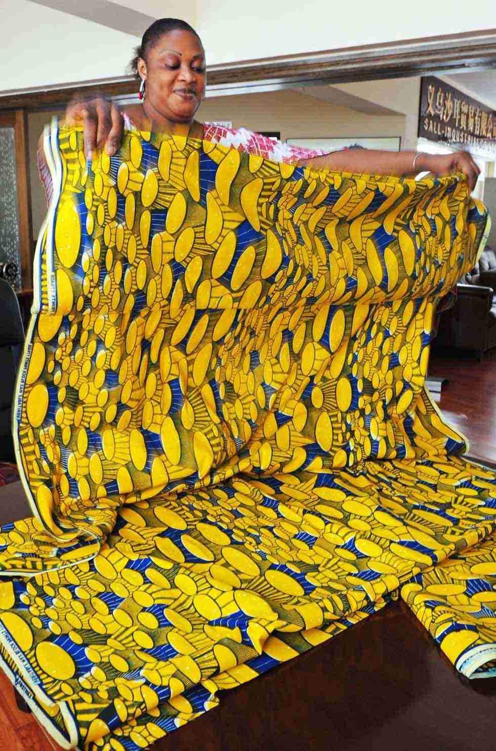 Senegalese merchant Mamadou Sall's wife Fatima arranges cloth for sale in Sall Industrial Co., Ltd. in Yiwu, east China's Zhejiang Province, July 15, 2012.(Xinhua/Tan Jin) 