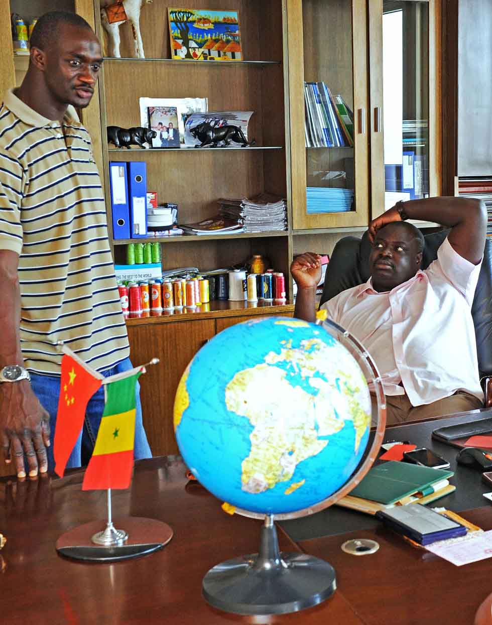 Senegalese merchant Mamadou Sall (R) and his brother Matar Sall talk about market situation in Sall-Industrial Co., Ltd. in Yiwu, east China's Zhejiang Province, July 15, 2012. (Xinhua/Tan Jin) 