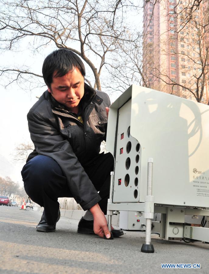 A man debugs the remote emission test equipment in Lanzhou, capital of northwest China's Gansu Province, Dec. 12, 2012. Two vehicles with the test system have been put into operation in Lanzhou recently. The system could collet and analyse emission data from a vehicle and record the vehicle number through a remote sensoring equipment without interrupting the traffic. (Xinhua/Huang Wenxin)