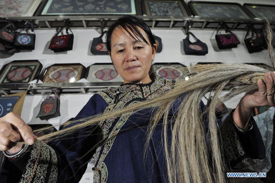 Wei Taohua, horse-tail embroidery craftswoman of Shui ethnic group, picks horsetail hairs in Sandu, southwest China's Guizhou Province, Dec. 12, 2012. (Xinhua/Ou Dongqu)