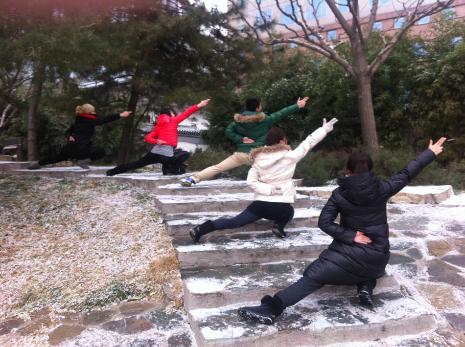 People pose "Aircraft Carrier Style" in snow in Beijing, capital of China, Dec. 12, 2012. A snow hit the city on Wednesday. (Minsheng Weekly/Liu Bowen)