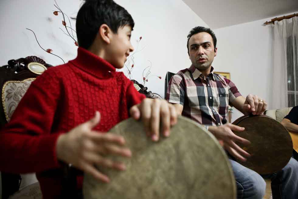 Peyam and his son Bai Long practise playing drum at their home in Yinchuan, capital of northwest China's Ningxia Hui Autonomous Region, March 15, 2012. (Xinhua/Zheng Huansong)