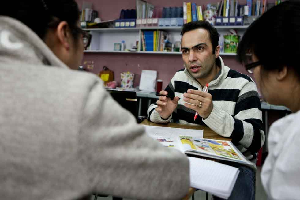 Peyam (C), president of Smile English School, has a discussion with colleagues in a meeting on teaching at his school in Yinchuan, capital of northwest China's Ningxia Hui Autonomous Region, March 15, 2012.(Xinhua/Zheng Huansong)