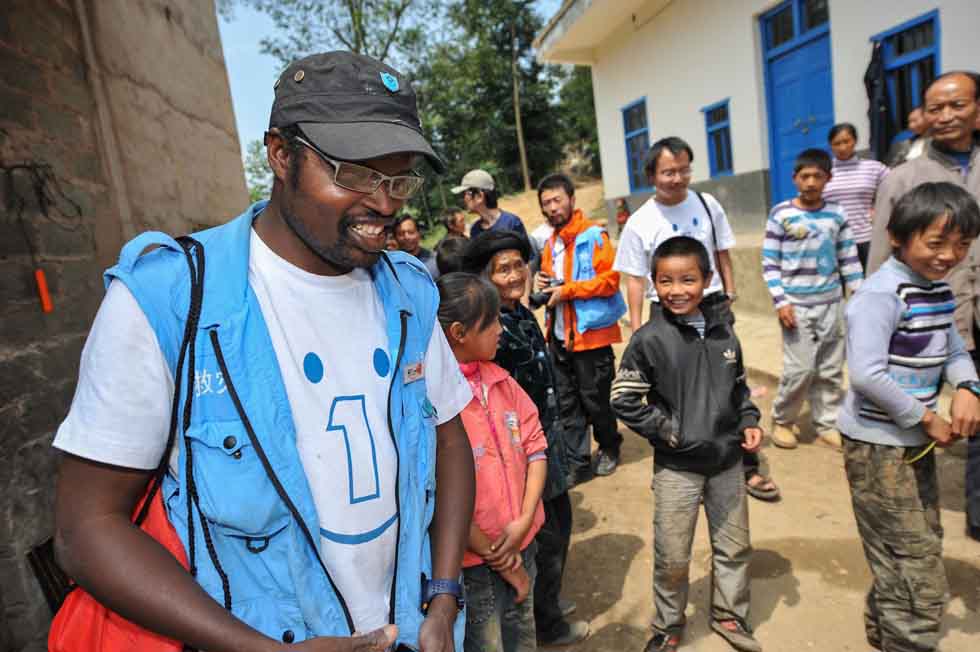 Diarra Boubacar (L) is surrounded by curious villagers when he seeks to give medical service in Boyi Village, Luozehe Town, Yiliang County, southwest China's Yunnan Province, Sept. 15, 2012.(Xinhua/Li Xin)