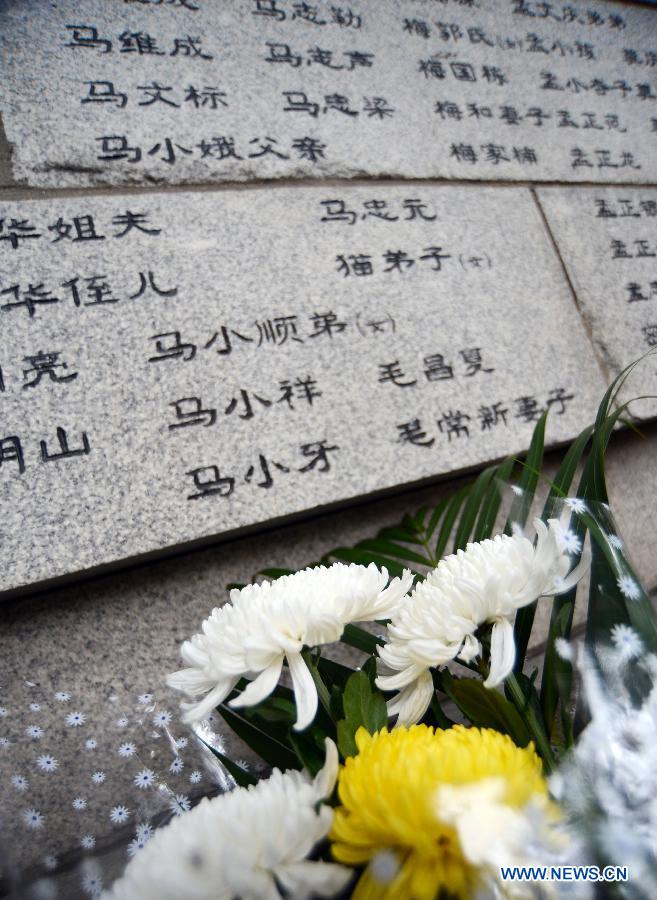 Chrysanthemums are presented in front of a memorial wall on which names of the Nanjing Massacre victims are engraved at the Memorial Hall of the Victims in Nanjing Massacre by Japanese Invaders in Nanjing, capital of east China's Jiangsu Province, Dec. 13, 2012, to mark the 75th anniversary of the Nanjing Massacre. (Xinhua/Li Ke)