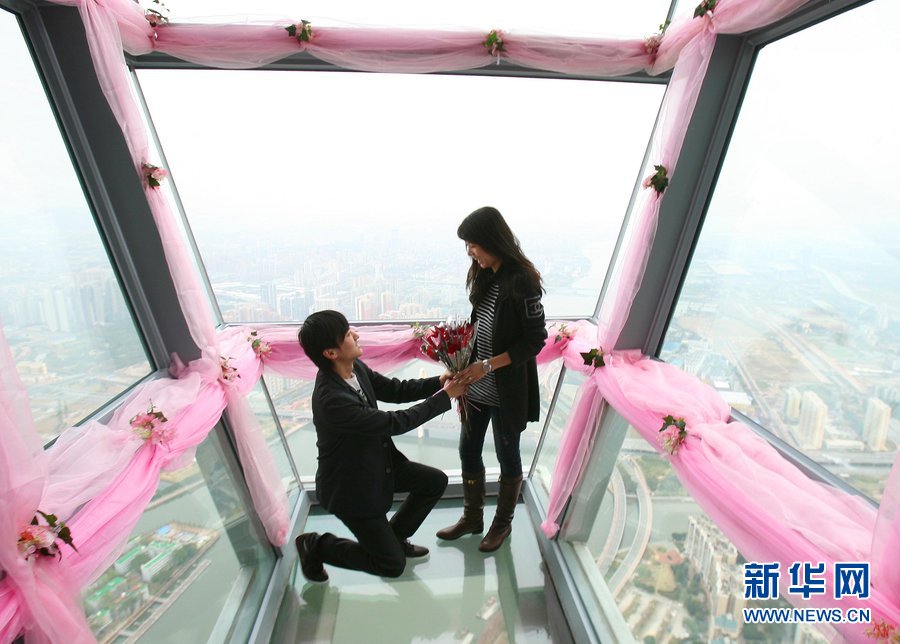A man carries a bunch of red roses and proposes to his girlfriend in the 600m high Canton Tower in Guangzhou, capital city of south China’s Guangdong province, Feb. 14, 2011. (Photo/Xinhua)