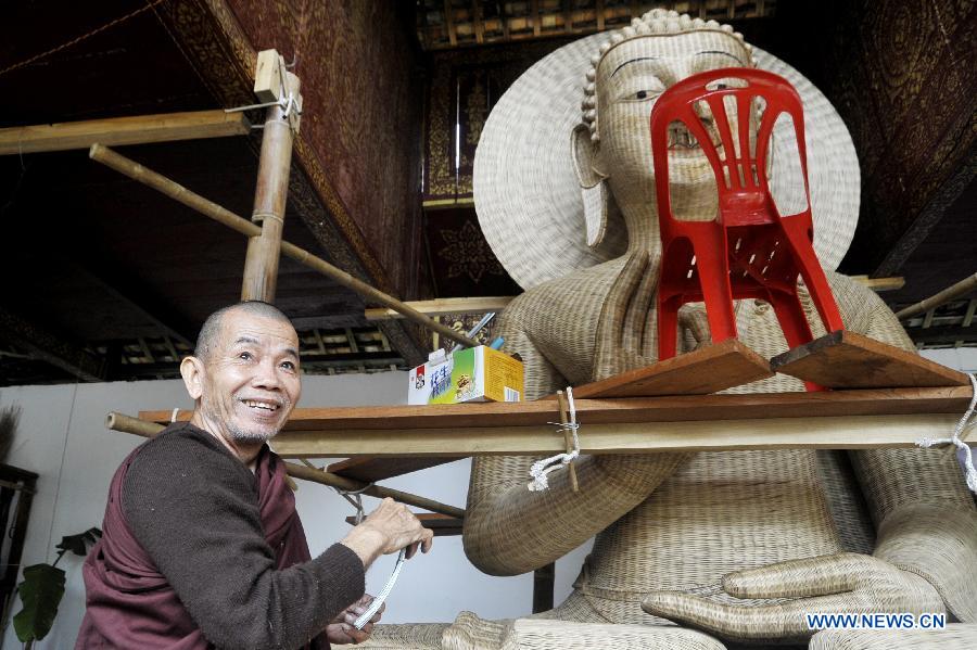 A monk weaves with bamboo to make a Buddha statue at a Dai folk custom park in Menghan township of Xishuangbanna Dai Autonomous Prefecture, southwest China's Yunnan Province, Dec. 9, 2012. In the town teeming with bamboos, local poeple take advanctage of the bamboo weaving handicraft to develop tourism. (Xinhua/Hao Yaxin) 