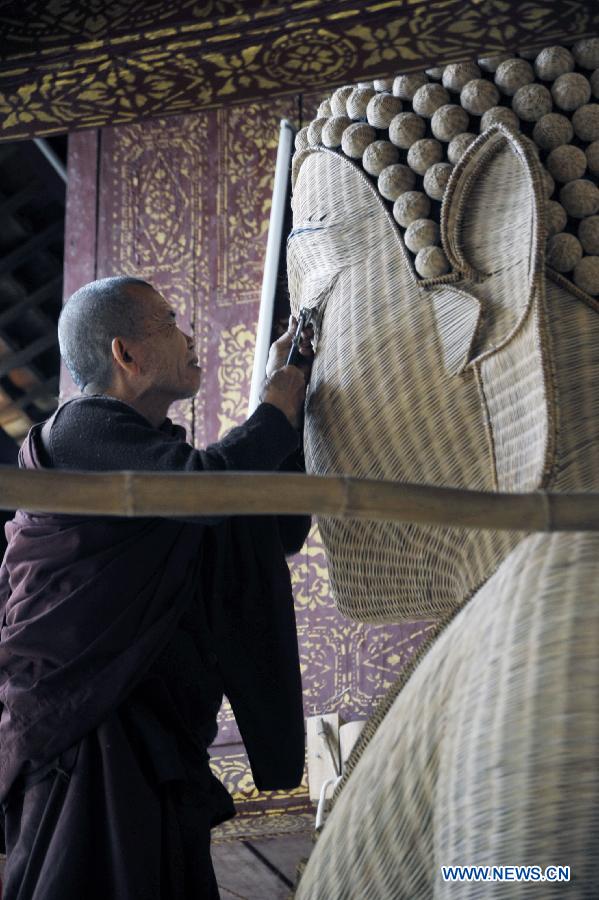 A monk weaves with bamboo to make a Buddha statue at a Dai folk custom park in Menghan township of Xishuangbanna Dai Autonomous Prefecture, southwest China's Yunnan Province, Dec. 9, 2012. In the town teeming with bamboos, local poeple take advanctage of the bamboo weaving handicraft to develop tourism. (Xinhua/Hao Yaxin)