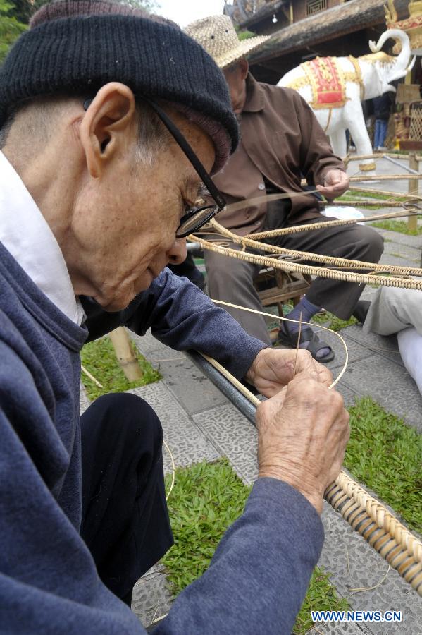 Villagers weave with bamboo to make a Buddha statue at a Dai folk custom park in Menghan township of Xishuangbanna Dai Autonomous Prefecture, southwest China's Yunnan Province, Dec. 9, 2012. In the town teeming with bamboos, local poeple take advanctage of the bamboo weaving handicraft to develop tourism. (Xinhua/Hao Yaxin)