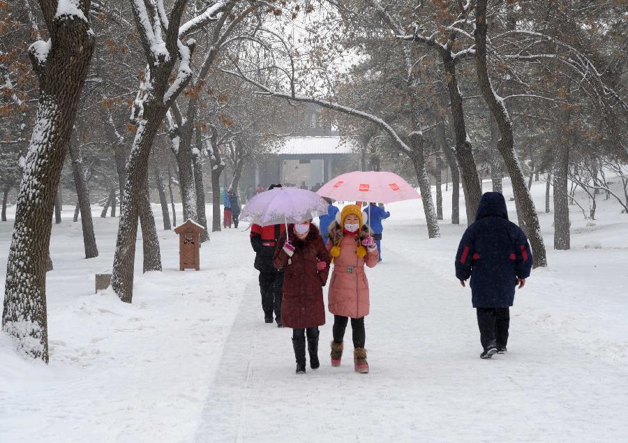 Visitors tour the Summer Resort in snow in Chengde, north China's Hebei Province, Dec. 14, 2012. Heavy snow battered parts of northern China these days. (Xinhua/Wang Kun)