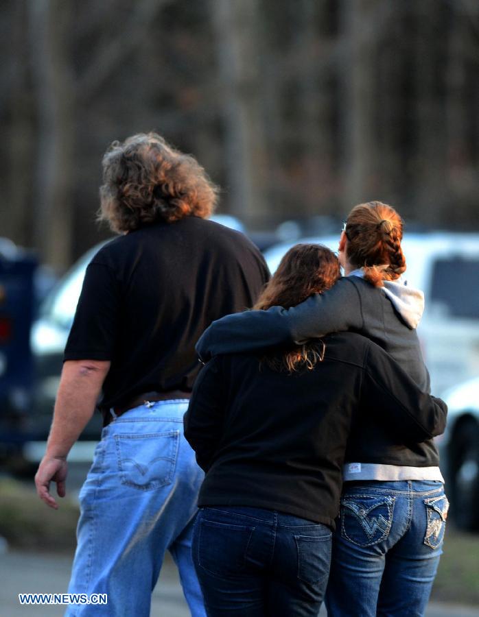 Family members of students of the Sandy Hook Elementary School comfort each other after the fatal school shooting in Newtown, Connecticut, the United States, Dec. 14, 2012. Police in U.S. state Connecticut said Friday that 18 children died on the scene at the school shooting here in Sandy Hook Elementary School, two more died later in the hospital. All together 8 adults were also dead. (Xinhua/Wang Lei) 