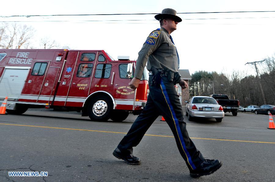 A policeman stands guard near the Sandy Hook Elementary School after the fatal school shooting in Newtown, Connecticut, the United States, Dec. 14, 2012. Police in U.S. state Connecticut said Friday that 18 children died on the scene at the school shooting here in Sandy Hook Elementary School, two more died later in the hospital. All together 8 adults were also dead. (Xinhua/Wang Lei) 