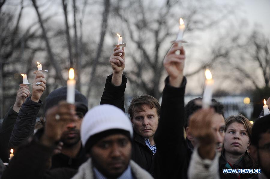 Supporters of gun control legislation hold candles during a rally to pay respect for the shooting victims in front of the White House in Washington, capital of the United States, Dec. 14, 2012, following a deadly shooting spree in an elementary school in Newtown, Connecticut, which took place earlier in the day. (Xinhua/Zhang Jun) 