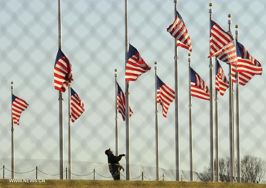 A National Park Service employee lowers a flag at the base of the Washington Monument to half staff to honor the victims of the Connecticut shooting incident in Washington D.C., capital of the United States, Dec. 14, 2012. U.S. President Barack Obama on Friday ordered U.S. flags to be flown at half-staff at the White House and all public buildings and grounds, as a mark of respect for the victims of a deadly shooting spree at Sandy Hook Elementary School in Newtown, Connecticut, which took place earlier in the day. (Xinhua/Wang Yiou) 