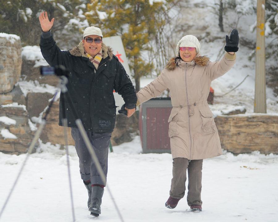 Citizens pose for photos in snow at a park in Tianjin, north China, Dec. 14, 2012. Citizens went outdoors to enjoy themselves after heavy snow swept Tianjin on Friday. (Xinhua)