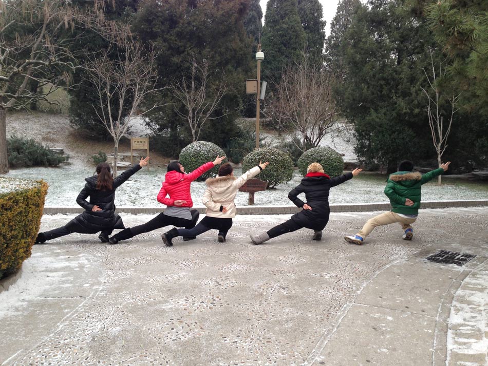 People pose "Aircraft Carrier Style" in snow in Beijing, capital of China, Dec. 12, 2012. A snow hit the city on Wednesday. (Minsheng Weekly/Liu Bowen)