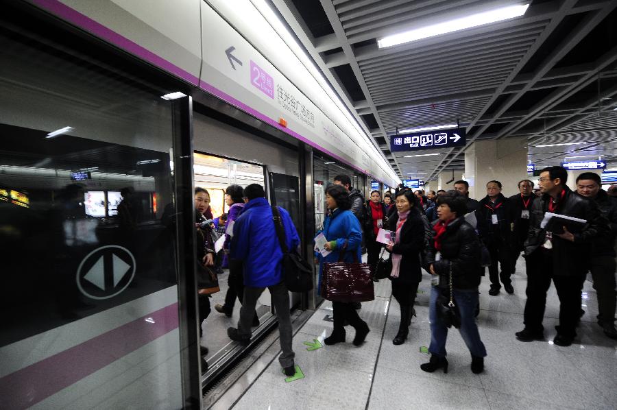 Journalists who are invited for test run line to board the train of Wuhan Subway Line No.2 in Wuhan, capital of central China's Hubei Province, Dec. 14, 2012. Subway Line No.2 is the first subway line of the city, also the first subway line across the Yangtze River. The construction of the project started in 2006. It is expected to be put into trial operation on Dec. 28. (Xinhua/Hao Tongqian) 