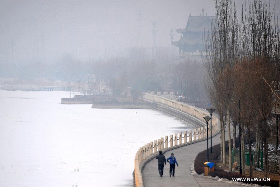 Citizens walk along the fog-shrouded Fenhe River in Taiyuan, capital of north China's Shanxi Province, Dec. 16, 2012. A heavy fog hit Shanxi on Sunday. (Xinhua/Zhan Yan)