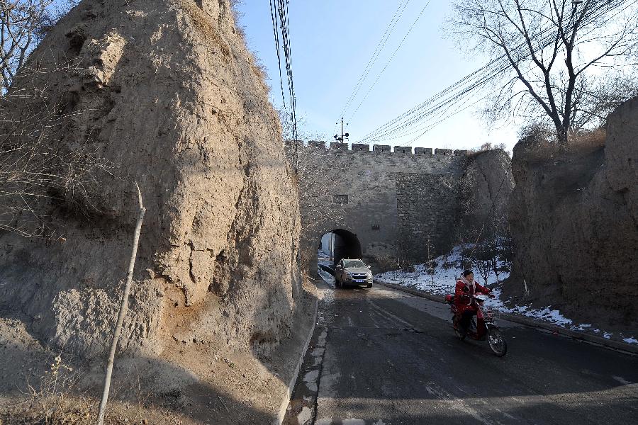 People travel past the west gate in the Ming Taiyuan County of Jinyuan Town in Taiyuan City, north China's Shanxi Province, Dec. 17, 2012. (Xinhua/Zhan Yan) 